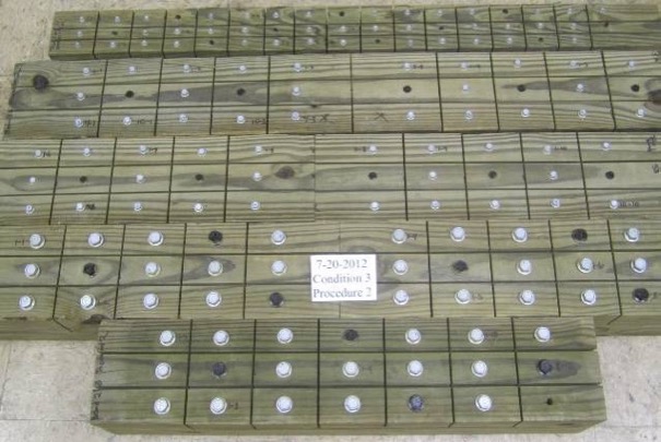 Figure 2: Fasteners with different coatings along with the benchmark, installed in wood and separated by kerf cuts.