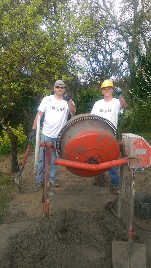 Doug Melcolm (l) and Rick Reid mixing cement for floor leveling.